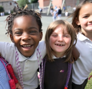 Dve mlade devojke u uniformi oponašaju pranje zuba četkicama od kartona